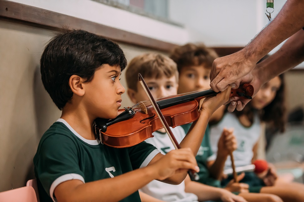 aluno do Sigma aprendendo a tocar violino